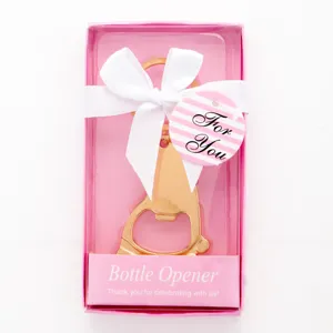 Llavero abridor de botellas de pies de bebe dorados con caja de regalo rosa y lazo blanco.