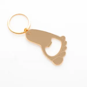 Vista detallada de llavero abridor en forma de pie dorado, accesorio metálico de cerca, diseño.