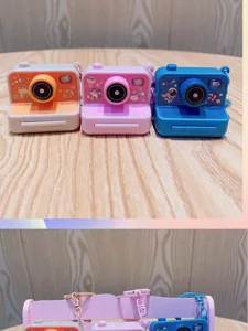 Vista detallada de mini llaveros de cámara luminosa en naranja, rosa y azul con lindos diseños.