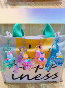 Cute cartoon quicksand keychain detail showing liquid glitter design and silicone strap for bags.