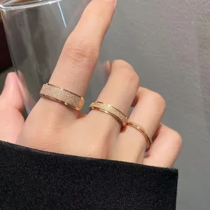 Nahaufnahme von drei minimalistischen roségoldenen mattierten Titanstahlringen zusammen.
