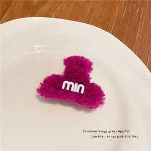 Detailed view of the cute magenta lambhair hair claw clip, fuzzy winter hair accessory.