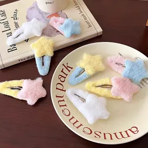 Dettaglio di fermagli per capelli a stella in peluche, consistenza morbida e colori pastel.