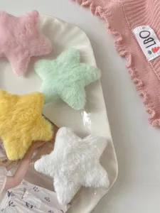 Close-up detail of cute plush star hair clips in pastel colors, soft texture design.