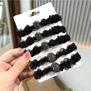 Close-up detail of black organza hair scrunchies featuring sparkling rhinestone balls and mesh design.
