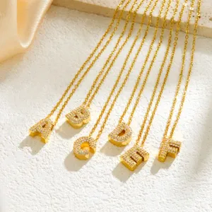 Close-up of sparkling rhinestone alphabet pendant necklaces in gold, elegant detail shot.