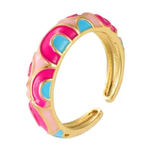 Vergulde open ring met levendig roze en blauw geemailleerd gekleurd boogpatroon.