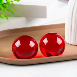 Red crystal ball detail view showing smooth polished surface and vibrant glass refraction.