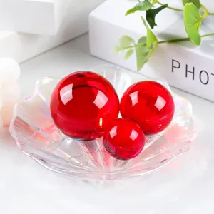 Detailed view of vibrant red glass crystal balls set in an iridescent shell tray, perfect decor.
