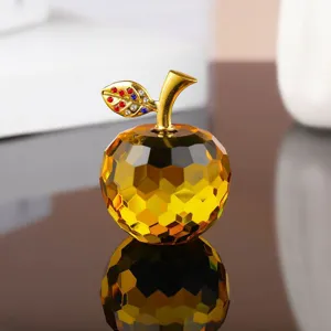Close-up of amber crystal apple figurine with rhinestone leaf and gold stem detail.