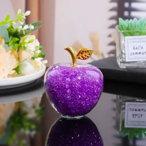 Crystal apple ornament detail view showcasing internal purple crystal beads and gold stem.
