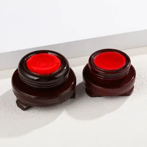 Wooden display base for crystal ball sphere holders with red velvet cushion interior details.