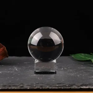 Clear transparent crystal glass ball close-up showing fine ornament details on base.