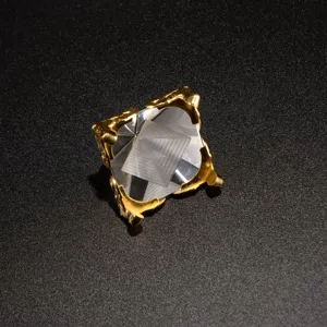 Crystal pyramid detail shot showing transparent geometric facets with golden metal claw mount base.