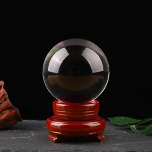 Clear crystal glass ball sphere ornament with wooden base for home decor and tabletop display.