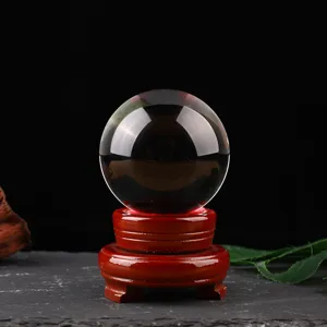 Transparent crystal glass ball with wooden base for home decor, clear sphere ornament.