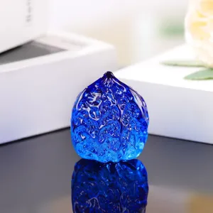 Close-up detail of blue glass walnut figurine, smooth texture and glossy reflection.