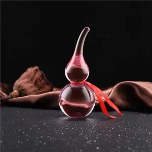 Crystal glass gourd ornament close-up shot, featuring a vibrant pink hue and delicate red ribbon.