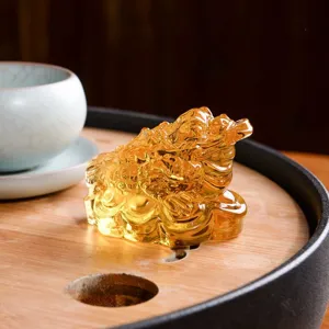 Detaillierte Nahaufnahme einer goldenen dreibeinigen Krötenfigur für Teetischdekoration.