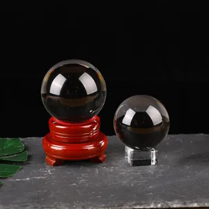 Detailed view of black crystal glass ball with wooden and acrylic stands for home decor.