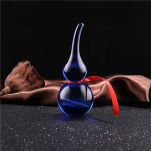 Blue crystal gourd ornament detail view, feng shui home decor piece with red ribbon decor.