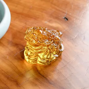 Nahaufnahme eines goldenen Kristall-Geldkröten-Ornaments auf Holztisch, feine Handwerkskunst.