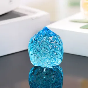 Blue glass walnut detail shot, showing fine textured surface and transparent crystal ornament.
