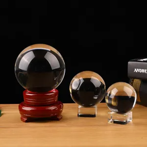 Clear crystal glass sphere ball with wooden and clear base for home decor display ornament.