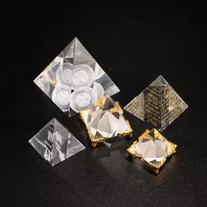 Crystal pyramid ornaments set with metal base and engraved ancient Egyptian patterns.