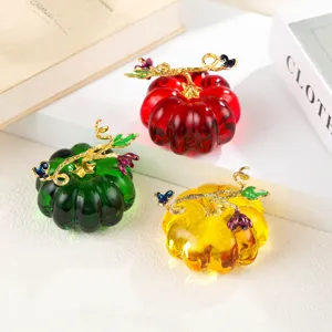Detailed view of colorful colored glaze pumpkin ornaments with exquisite golden stems and flowers.