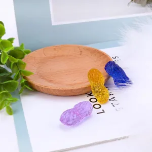 Crystal peanut ornament detail shot showcasing the translucent purple, yellow and blue colors.