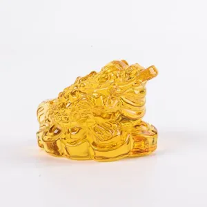 Nahaufnahme des bernsteinfarbenen Kristall-Geldkröten-Ornaments mit transparenter Goldtextur.