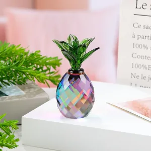 Closeup of a colorful crystal pineapple ornament with faceted body and green glass leaves.