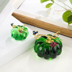 Green glass pumpkin ornament detail shot, showing exquisite gold vines and butterfly decor.
