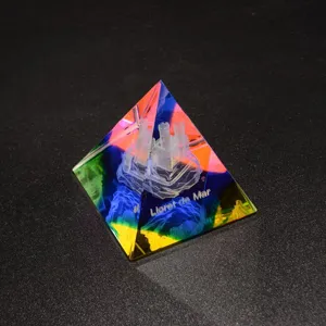 Crystal pyramid ornament with laser engraved castle, colorful refraction detail view.