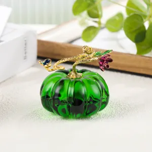 Detailed view of the exquisite glass pumpkin ornament with golden stem and floral design.