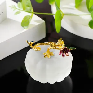 Detailed view of a crystal glass pumpkin figurine with elegant gold floral branch decoration.