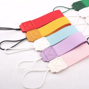 Close-up detail of colorful fabric cup wrist straps with leather connectors and string loops.