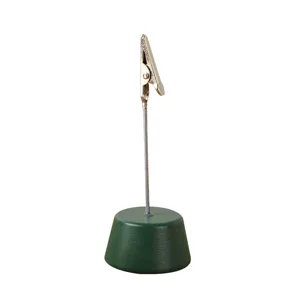 Minimalist desktop memo clip with a green conical base and silver alligator holder for notes.