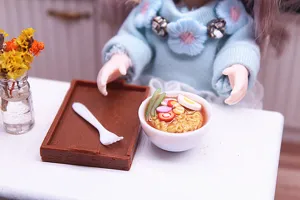 Miniature dollhouse ramen bowl set detail showing handmade clay instant noodles and tray.