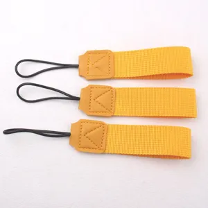Detailed view of portable yellow cup lanyard with leather stitching and black hanging loop.
