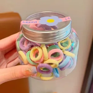 Colorful elastic hair ties for kids, soft seamless baby hair bands in clear jar storage.