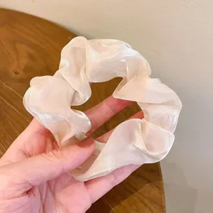 Λεπτομέρεια γυαλιστερού scrunchie από οργάντζα, απαλή υφή για καθημερινό κομψό styling.