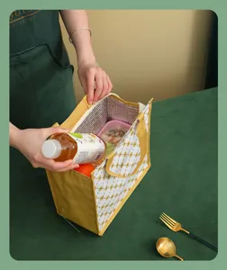 Detalle de bolsa térmica para almuerzo, patrón geométrico amarillo, bolsa bento portátil.
