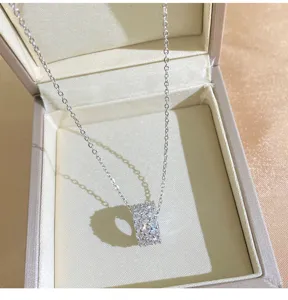 Delicate zilverkleurige zirkonia cilinder hanger ketting detailopname, elegant sieraad.