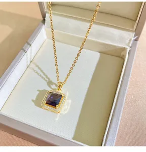 Detailed view of the elegant gold chain necklace with a square purple stone pendant.