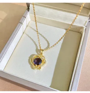 Detail shot of gold-plated titanium steel purple zircon heart pendant necklace in box.