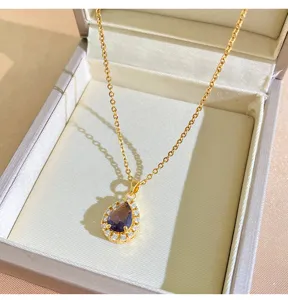 Detail shot of the elegant teardrop purple zircon necklace in a classic jewelry box.