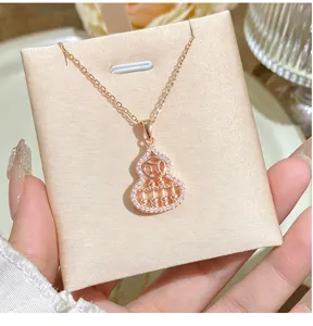 Closeup detail of the sparkling rose gold hollow gourd abacus pendant necklace on display.
