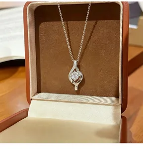 Detail shot of a delicate geometric cubic zirconia pendant necklace in a velvet jewelry box.